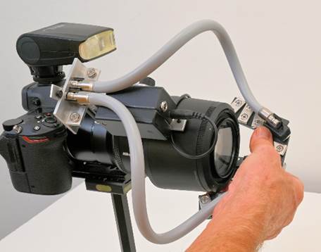 A hand holding a camera
Description automatically generated