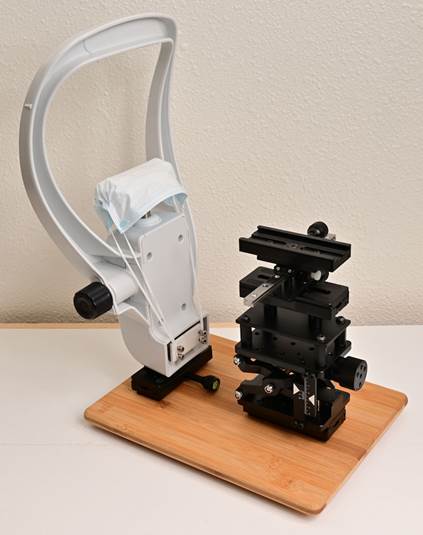 A white and black microscope with a face mask on
Description automatically generated