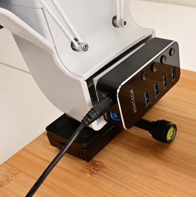 A black and white device with a black cord
Description automatically generated